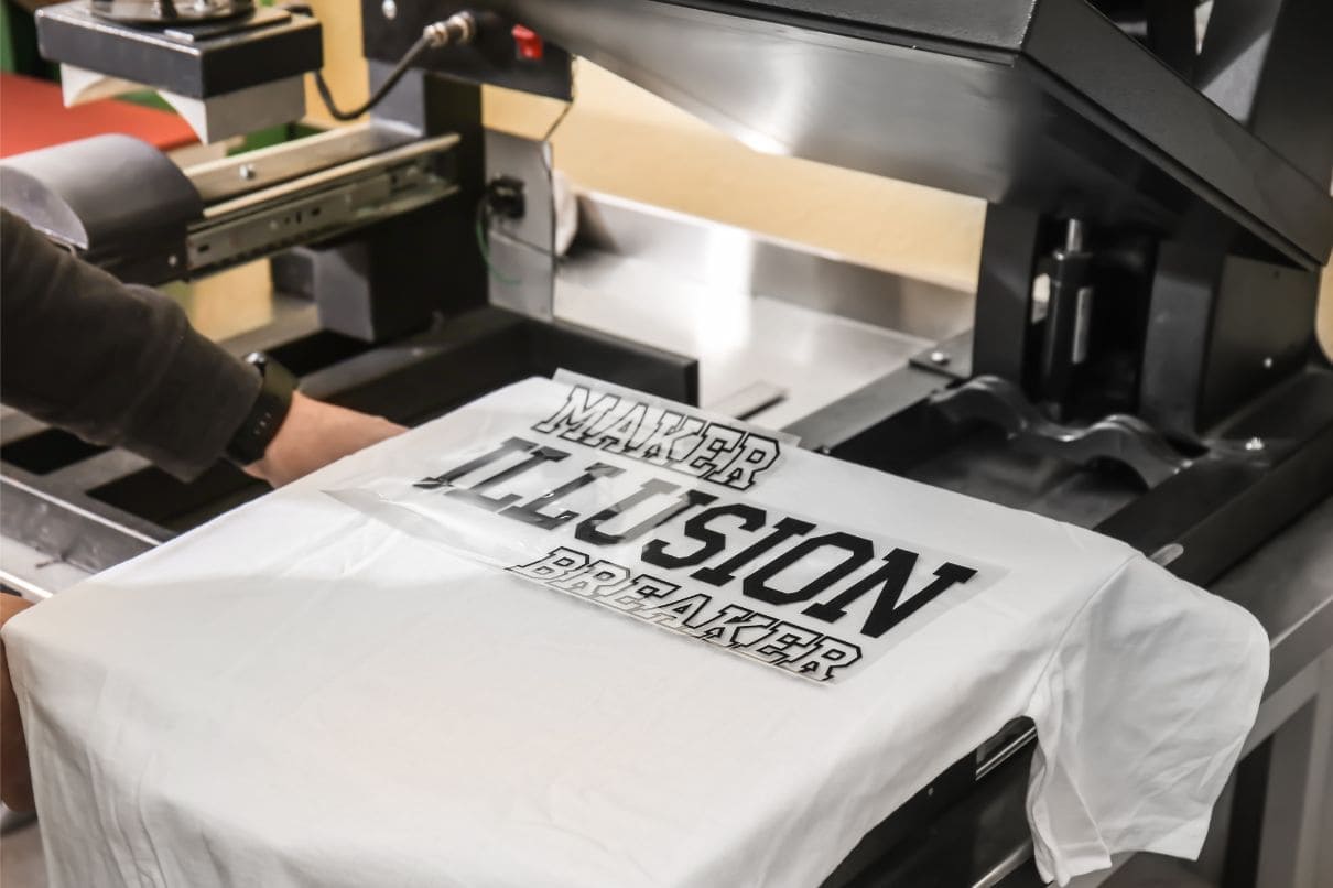 A man operating a machine to create a t-shirt.